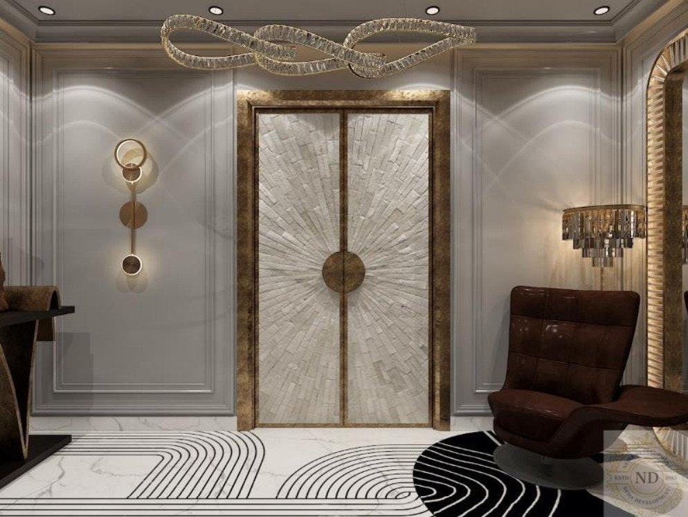 Araya Presidia, Araya Presidia, Gurugram — An entrance vestibule. A stone double door with a brass sunburst inlay, flanked by ribbed plaster and read against a graphic black-and-white floor.