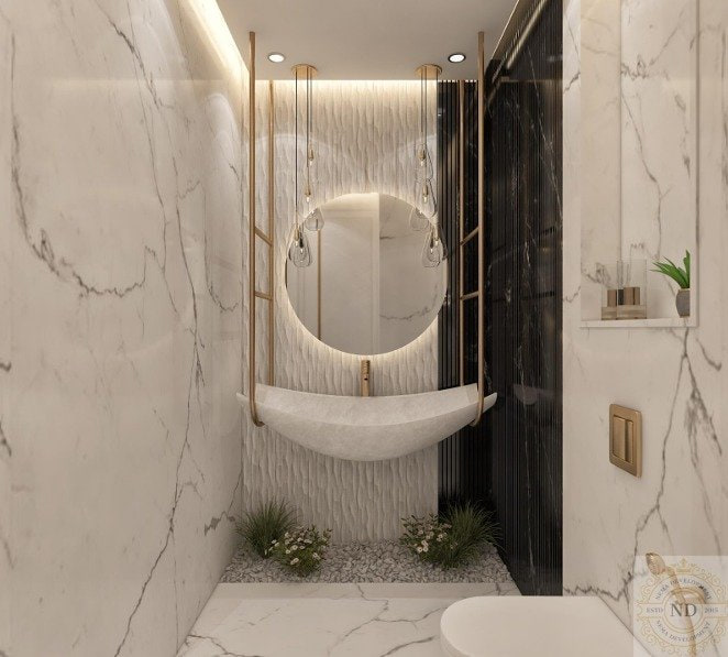 Trump 37F, Trump Towers, Gurugram — A principal bathroom worked as one continuous marble surface. The vanity turns a radius rather than meeting the wall at a corner, and a backlit oval mirror sits off-axis above it.